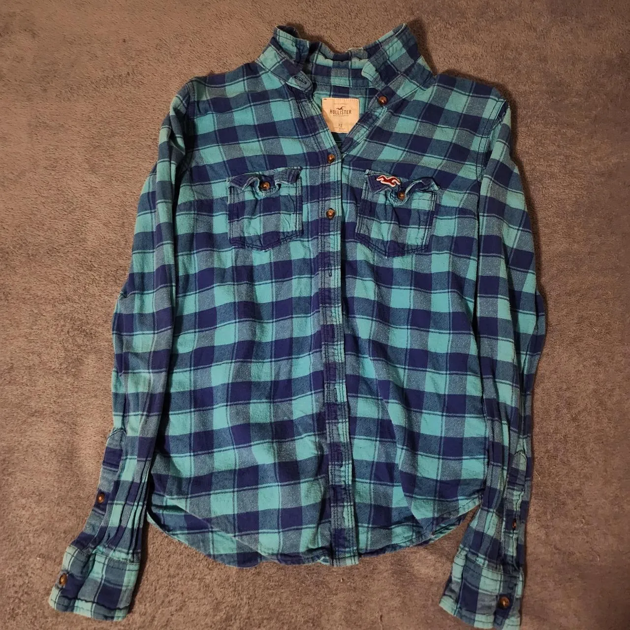 Hollister Co. women's blue and teal plaid shirt laid flat